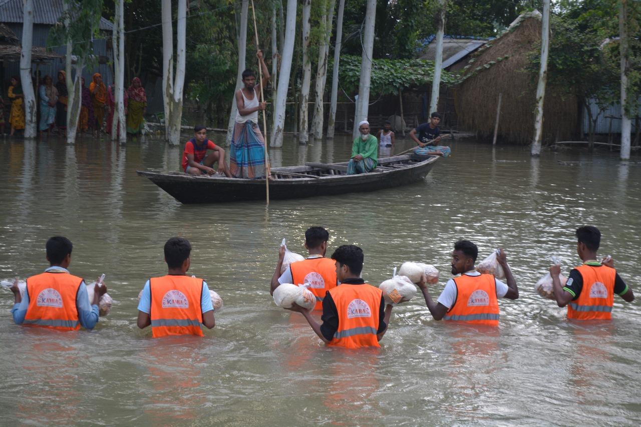 কোমরপানি ভেঙে ত্রাণ নিয়ে এগিয়ে চলা স্বেচ্ছাসেবক দল